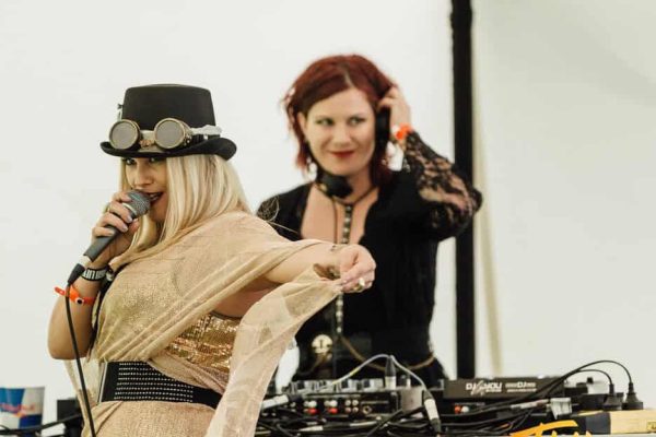 Female singer with microphone and DJ behind her at Ocean Eagle cruise.